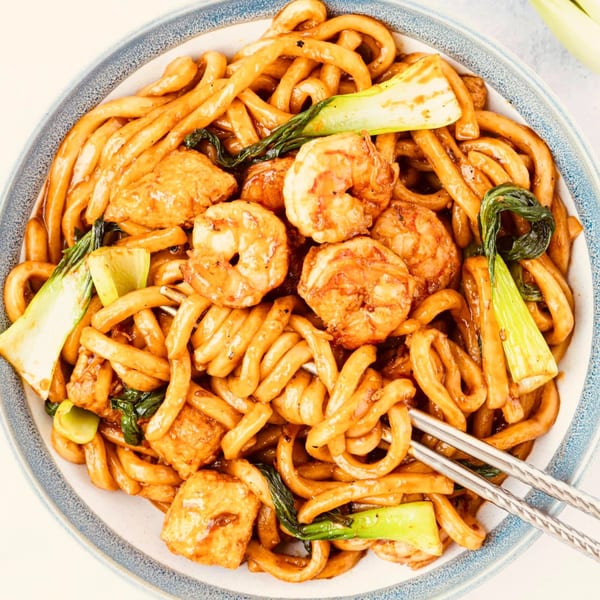A close-up of Pho La La's stir-fried udon noodles with shrimp, tofu, and bok choy.
